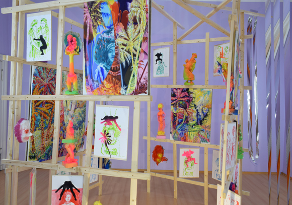 Martin von Ostrowski: Koloniale Fragmente, Installation, 
						Holzlatten, Schrauben, 
						6 Gemälden je 80 x 60 cm, 2 Gemälden je 105 x 85 cm,                    
						10 gefassten Holzskulpturen bis 57 cm Höhe, 28 Tuschezeichnungen 
						teilweise mit  Sprühlack bearbeitet auf Holzplatten getackert, je 42,0 x 29,7 cm, 
						10 gefasste Maskenabformungen aus Pappmaché, Maße 2,7 x 4,5 x 5,0 m