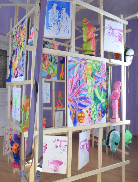 Martin von Ostrowski: Koloniale Fragmente, Detail der Installation, 
						Holzlatten, Schrauben, 
						6 Gemälden je 80 x 60 cm, 2 Gemälden je 105 x 85 cm,                    
						10 gefassten Holzskulpturen bis 57 cm Höhe, 28 Tuschezeichnungen 
						teilweise mit  Sprühlack bearbeitet auf Holzplatten getackert, je 42,0 x 29,7 cm, 
						10 gefasste Maskenabformungen aus Pappmaché, Maße 2,7 x 4,5 x 5,0 