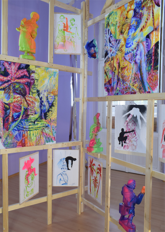 Martin von Ostrowski: Koloniale Fragmente, Detail der Installation, 
						Holzlatten, Schrauben, 
						6 Gemälden je 80 x 60 cm, 2 Gemälden je 105 x 85 cm,                    
						10 gefassten Holzskulpturen bis 57 cm Höhe, 28 Tuschezeichnungen 
						teilweise mit  Sprühlack bearbeitet auf Holzplatten getackert, je 42,0 x 29,7 cm, 
						10 gefasste Maskenabformungen aus Pappmaché, Maße 2,7 x 4,5 x 5,0 