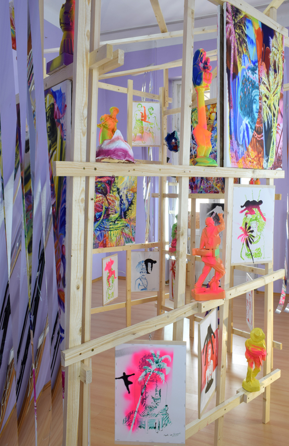 Martin von Ostrowski: Koloniale Fragmente, Detail der Installation, 
						Holzlatten, Schrauben, 
						6 Gemälden je 80 x 60 cm, 2 Gemälden je 105 x 85 cm,                    
						10 gefassten Holzskulpturen bis 57 cm Höhe, 28 Tuschezeichnungen 
						teilweise mit  Sprühlack bearbeitet auf Holzplatten getackert, je 42,0 x 29,7 cm, 
						10 gefasste Maskenabformungen aus Pappmaché, Maße 2,7 x 4,5 x 5,0 