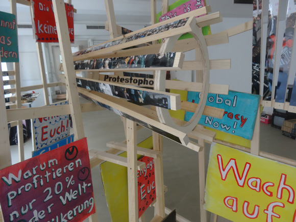 Martin von Ostrowski: P-Zickzack, 2017, Installation aus 4 Holzgittern (je 240x150x5 cm), 4 Ölgemälden (je 80x60cm), 
						5 in Streifen zerschnittenen Fotos (je 75x50 cm), 
						8 gefaltete Fotos (je 30x42 cm), 20 bemalte Kartonschilder,  
						Gesamtmaße der Installation: 240cm (Höhe), 400 cm (Länge), 150 cm (Tiefe)