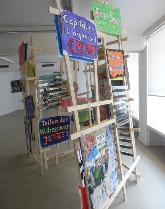 Martin von Ostrowski: P-Zickzack, 2017, Installation aus 4 Holzgittern (je 240x150x5 cm), 4 Ölgemälden (je 80x60cm), 
						5 in Streifen zerschnittenen Fotos (je 75x50 cm), 
						8 gefaltete Fotos (je 30x42 cm), 20 bemalte Kartonschilder,  
						Gesamtmaße der Installation: 240cm (Höhe), 400 cm (Länge), 150 cm (Tiefe)